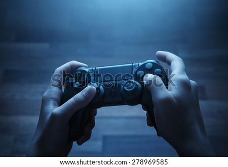 Close up of child hands playing the video game at night