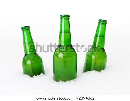 Beer bottles in the snow over white background