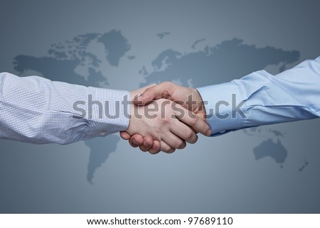Business handshake with world map in the background