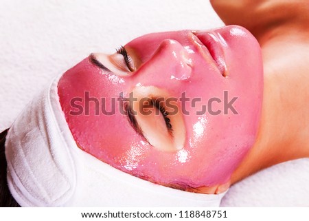 Young beautiful woman with moistening fruit facial mask at beauty salon