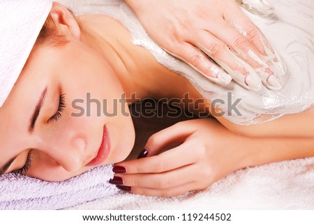Young woman with slimming body thermal mask on her back. Spa Treatment.