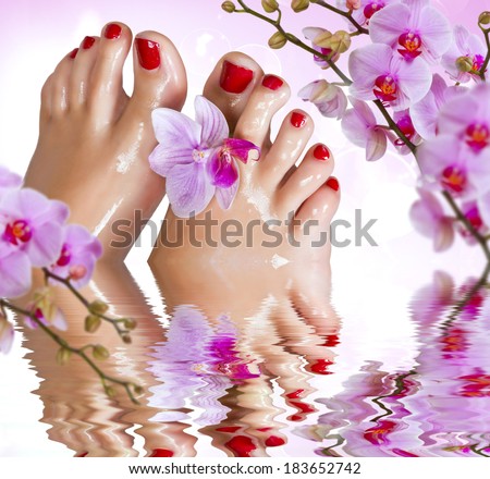 Wet feet with orchid above the water.