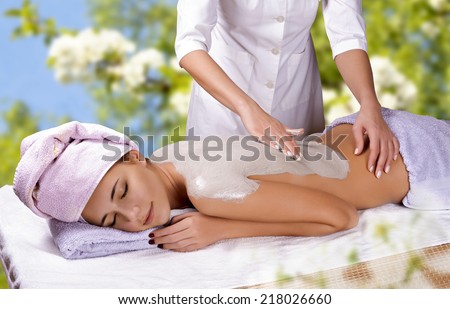 Young woman with slimming body thermal mask on her back. Spa Treatment.