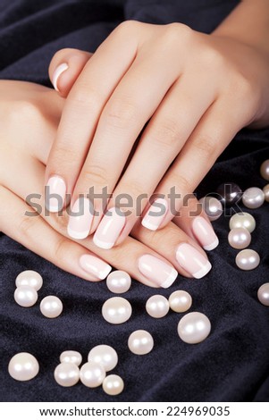 Beautiful woman\'s nails with french manicure and pearls.