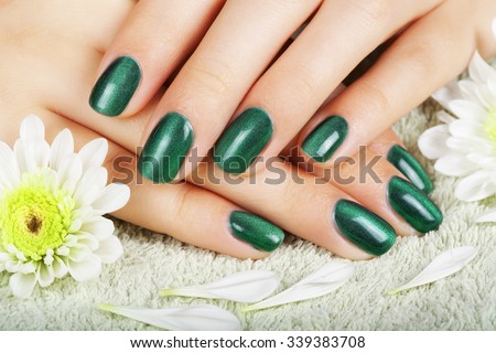 Women\'s manicure with effect of cat\'s-eye gel polish on the nails.