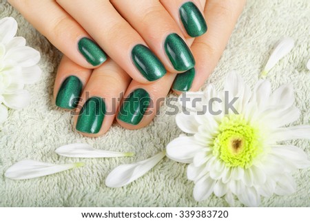 Women\'s manicure with effect of cat\'s-eye gel polish on the nails.