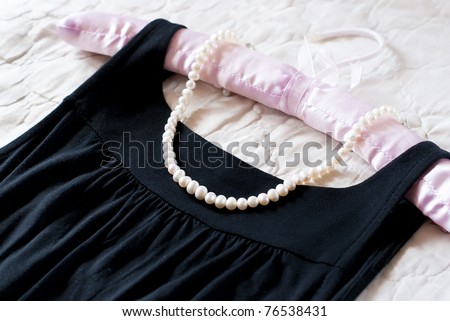 Black dress and pearl necklace on the clothes rack