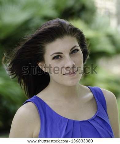 Head shot portrait of woman in blue dress outside