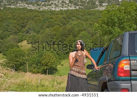 Woman breaking down of car and discussing with her telephone