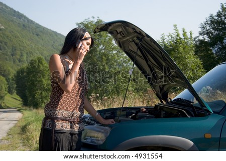 Woman breaking down of car and discussing with her telephone