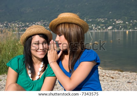 Woman speaking in the ear of another woman
