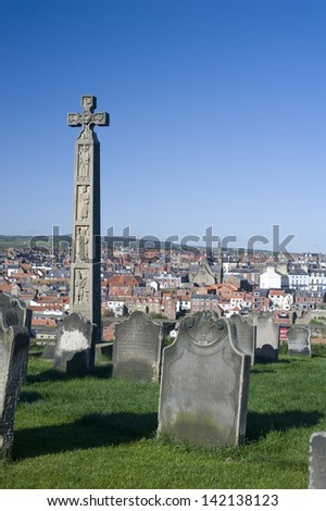 Caedmons Cross, an ornately carved and inscribed stone celtic cross commemorating, Caedmon, an Anglo-Saxon, poet and songwriter, in St Marys Graveyard in Whitby