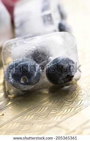 Fresh berry fruits frozen in ice cubes