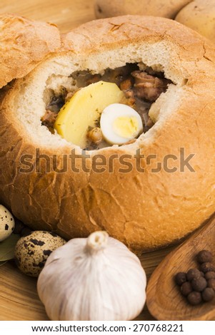 traditional white borscht (zurek) with sausage,egg and mushrooms in bread as bowl
