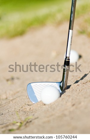 Golf Ball in Trap with Sand Wedge about to strike the golf ball