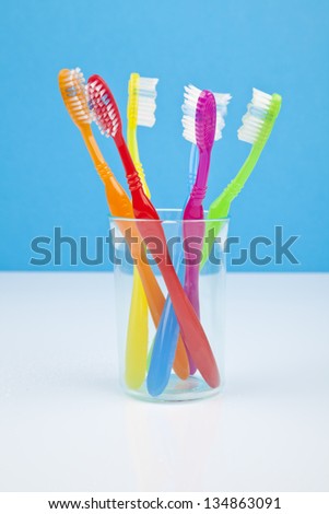 colorful toothbrushes in a water glass