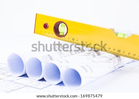rolls of architectural projects and plans with yellow level on top