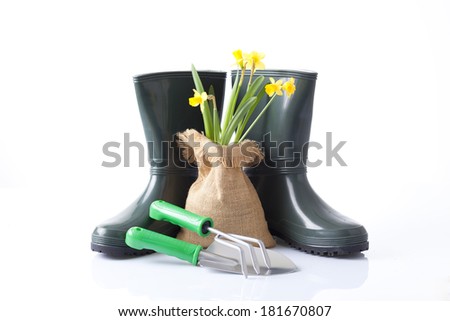 garden tools, boots and spring flowers isolated on white