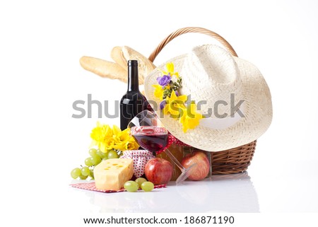 wine tasting and summer picnic concept picnic basket with bottle of wine,fruits, bread and summer hat isolated on white