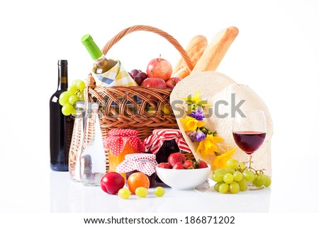 picnic basket with bottle of wine,fruits, bread and summer hat isolated on white