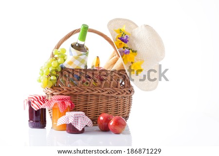 picnic basket with wine, fruits and summer hat isolated on white