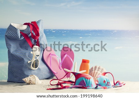 beach bag, sun glasses and flip flops on a tropical beach, retro style