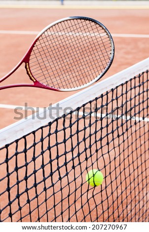 tennis ball and tennis racket on clay court