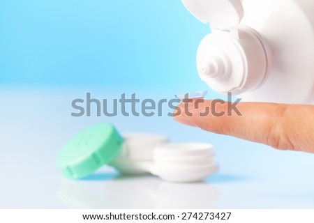 Contact lens, case and bottle of solution close-up