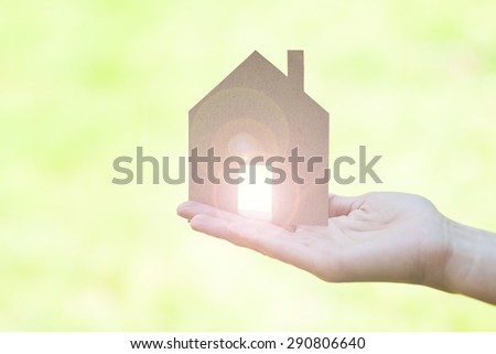 dream house in a female hand, light blurs coming through