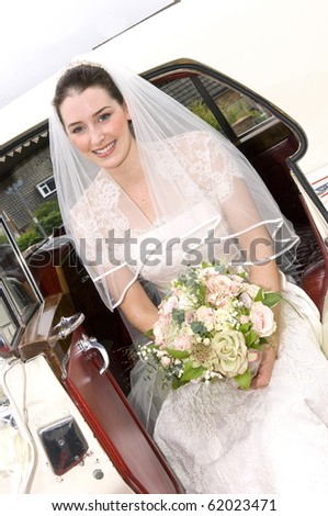 A radiant looking bride getting out of wedding car