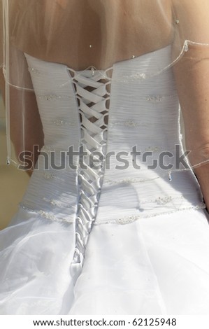 A close up of the back of a bride\'s dress showing the detail and lacing