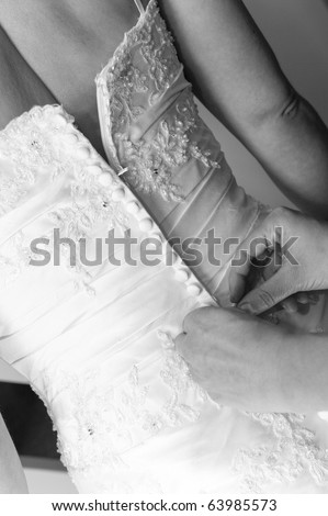 Close up of a bride\'s dress being done up