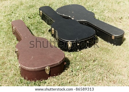 Three guitar cases lying on the ground