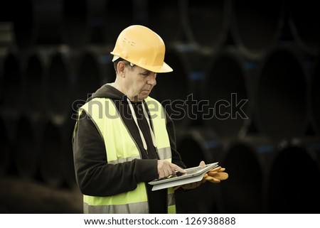 builder with small computer and gloves