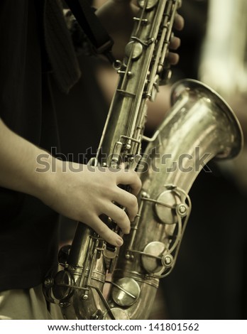 jazz band playing on the street, selective focus on the hands with sax