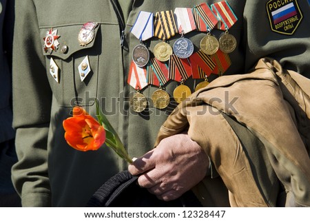 hand of war veteran with tulip on Victory Day in Russia (editorial photo, focus point on hand)