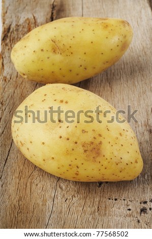 two fresh potato on wood background
