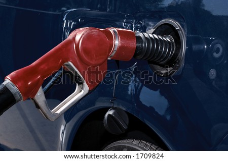 gasoline pump nozzle filling car\'s gas tank
