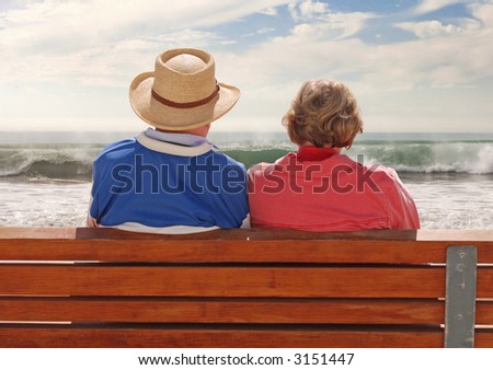 A senior adult couple sitting at a benchand, enjoying their time at the beach.