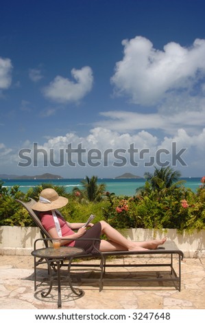 Young woman relaxing on a veranda with an aqua blue ocean and blue sky in the background