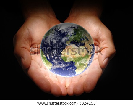 Hands holding the earth on a black background