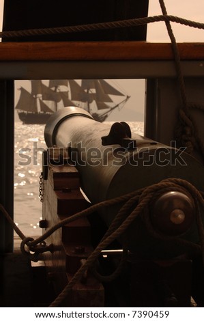 Gun cannon on vintage sailing ship aiming at another sailing vessel