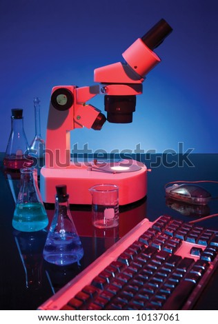 Stereoscopic microscope, chemistry flasks and computer keyboard on blue background