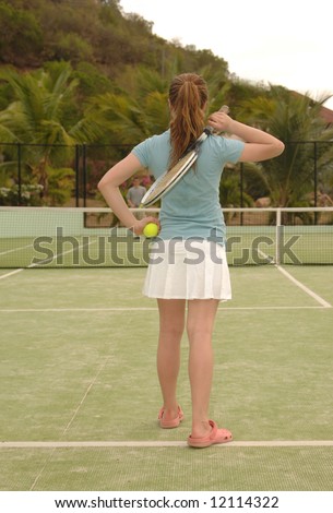 Girl ready to serve on an outdoor tennis court