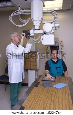 X-ray technician giving a man an x-ray of his hand