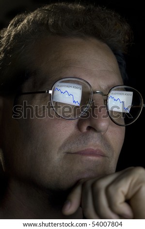 close-up of an investor with an ascending stock portfolio graph reflected in his glasses.