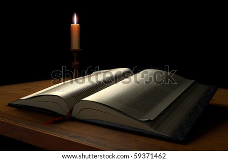 An open book on a dark background illuminated with a candle
