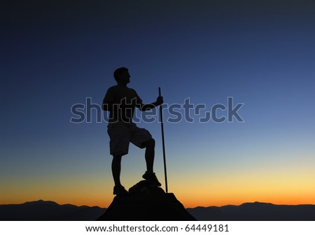 Man at the top of a mountain range at sunrise