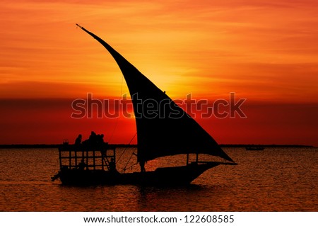 Fishermen Dhow Boat Coming Back Home At Sunset From A Long Day In The Sea. Taken At Nungwi Village, Zanzibar Island, Tanzania