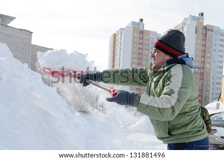Man shoveling snow on a sidewalk after a snow storm